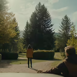 the lady is walking toward the car on the road