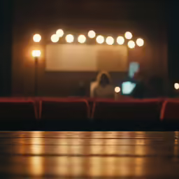 the floor of a theater with a person sitting in front of a screen