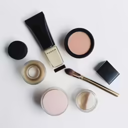 a table top with three different colored cosmetics