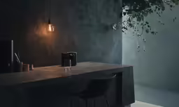 an artful black lamp, a drink dispenser and chair