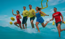 five people running out of the ocean with life jackets