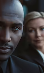 the man and woman are looking out over their shoulder