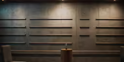 two chairs and a pedestal in front of a wall with wooden dividers