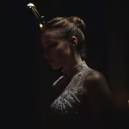 a person in a dress looking down wearing a golden tiara