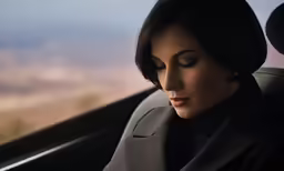 a woman is driving through a mountain side