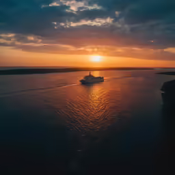 a cruise ship out in the ocean at sunset