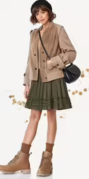 a woman standing up and holding her handbag