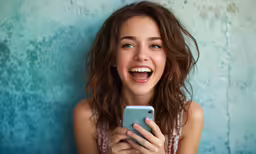 a girl smiles while looking at her phone