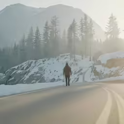 a man is walking down the middle of a road