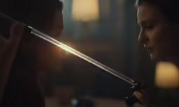 a young girl staring at another woman with sword