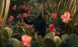 a man in a suit standing next to plants
