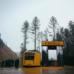 a bus in front of a yellow sign and people walking in the rain
