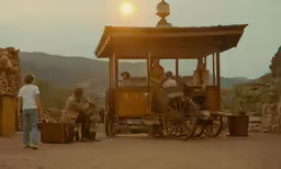 people are gathered outside by a small carriage