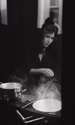 a woman standing in front of a stove cooking