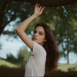 a woman posing for the camera with her arm up and hand over her head