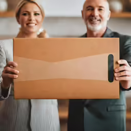 man holding a large box while woman puts the lid on it