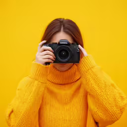 a person that is holding a camera up in front of her