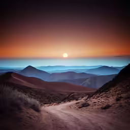 the sun sets over mountains in a desert landscape