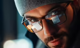 the man in glasses has two paper on his forehead