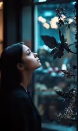 the woman is looking through the window in the dark