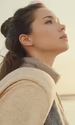 a woman looks to the side and has her head tilted