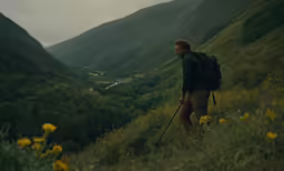 a man walking uphill towards a valley