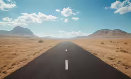 an open road leads to mountains and deserts in the desert