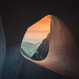 view from an open, winding tunnel leading to the mountains