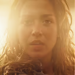 a girl looking away as the sun shines down on her