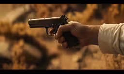 a person holding a small gun in his hand
