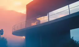 man is walking on the balcony of a building at sunset