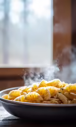 a bowl full of pasta with a steam coming out of it