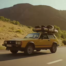 a yellow suv with packed luggage is riding down the street
