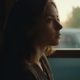 a woman looking out the window during sunset