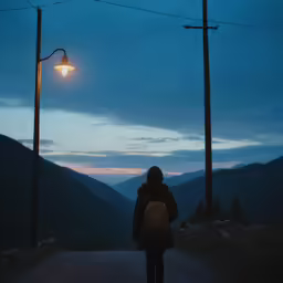 the person is standing under two street lights
