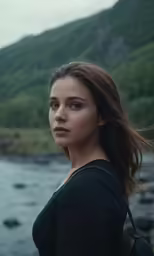a woman with long hair in front of water