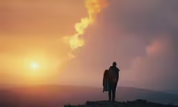 a person standing on top of a hill at sunset