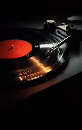 a record player with a red disc in the middle