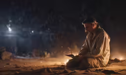 a person sitting down with a flashlight on