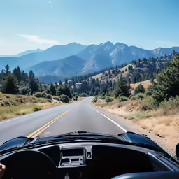 a view from a vehicle shows the road through hills