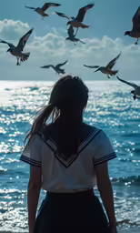 the back view of a girl looking at some seagulls flying over the water