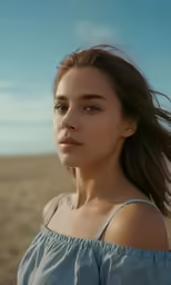 a woman with long hair wearing a shirt in the desert