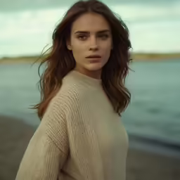 young girl in natural dress by ocean wearing fur stolel