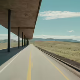 the road goes underneath an empty building near the field