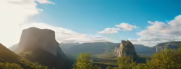 a group of tall rocky mountain peaks sitting next to a forest
