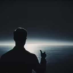 the silhouette of a person in a dark room with water