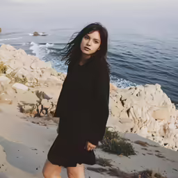 an adorable woman posing for a picture by the ocean