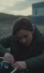 a girl with a green jacket looks at her cell phone