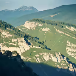 a landscape with some very large rocks and trees on a hill