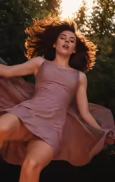 a woman wearing a brown dress dancing with her arms outstretched